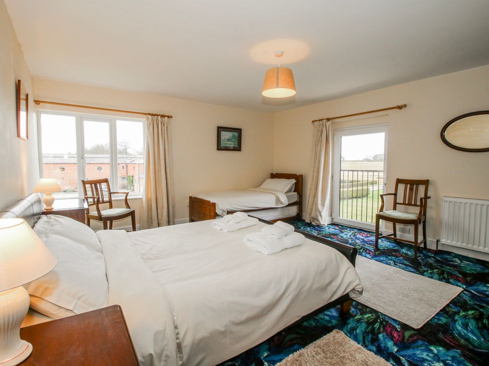 A bedroom with two beds and window views at The Manor House at Kenwick Lodge Cockshutt near Ellesmere