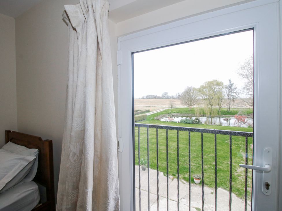 A bedroom with a view of a garden pond at The Manor House at Kenwick Lodge in Cockshutt near Ellesmere