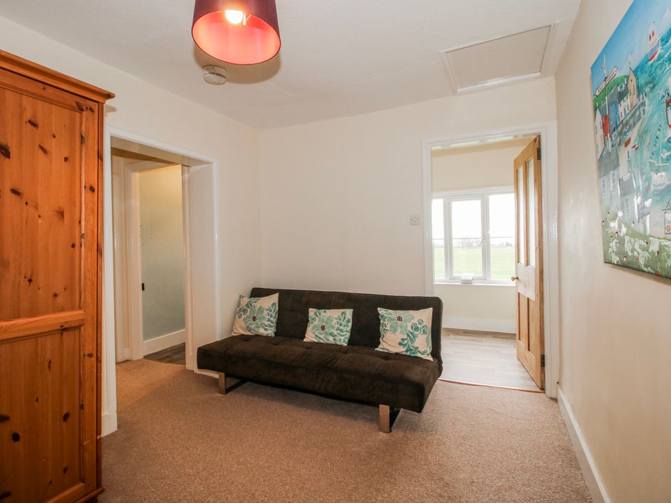 A living room with an armoire and a sofa at The Manor House at Kenwick Lodge in Cockshutt near Ellesmere