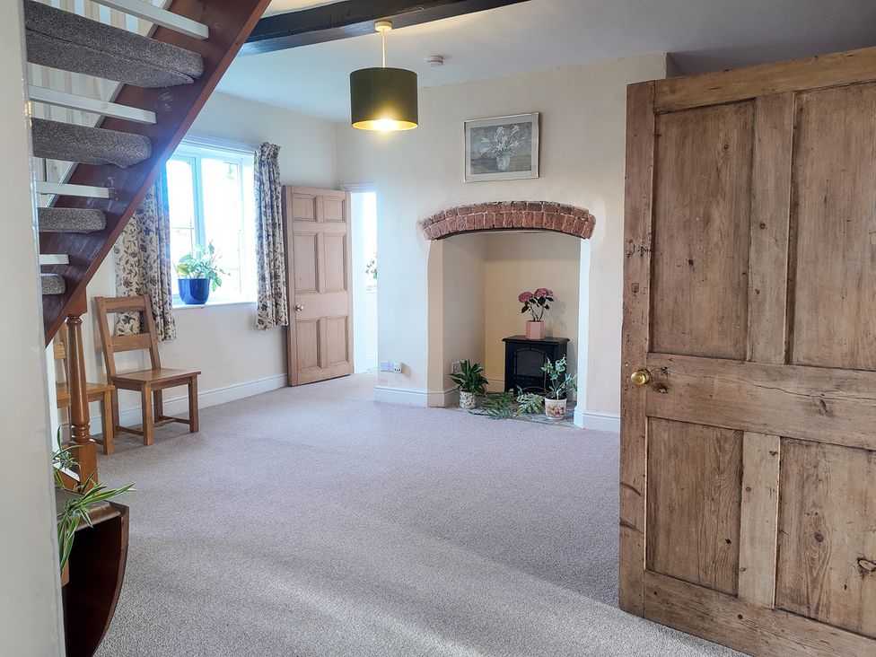 A living room with a fireplace and a chair at The Manor House at Kenwick Lodge, Cockshutt near Ellesmere