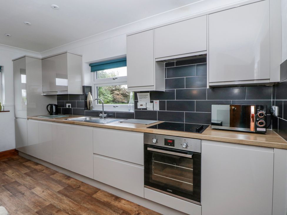 A kitchen with cabinets, sink, and appliances at Blaenywawr near Lampeter