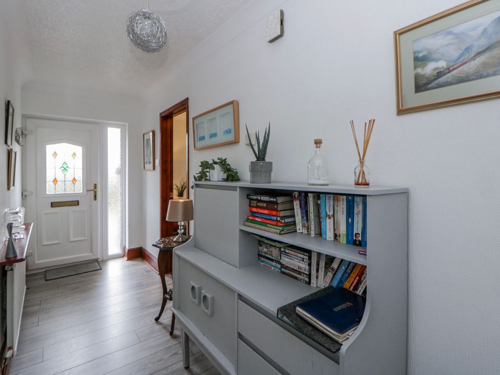 A hallway with a bookshelf and front door at Blaenywawr near Lampeter