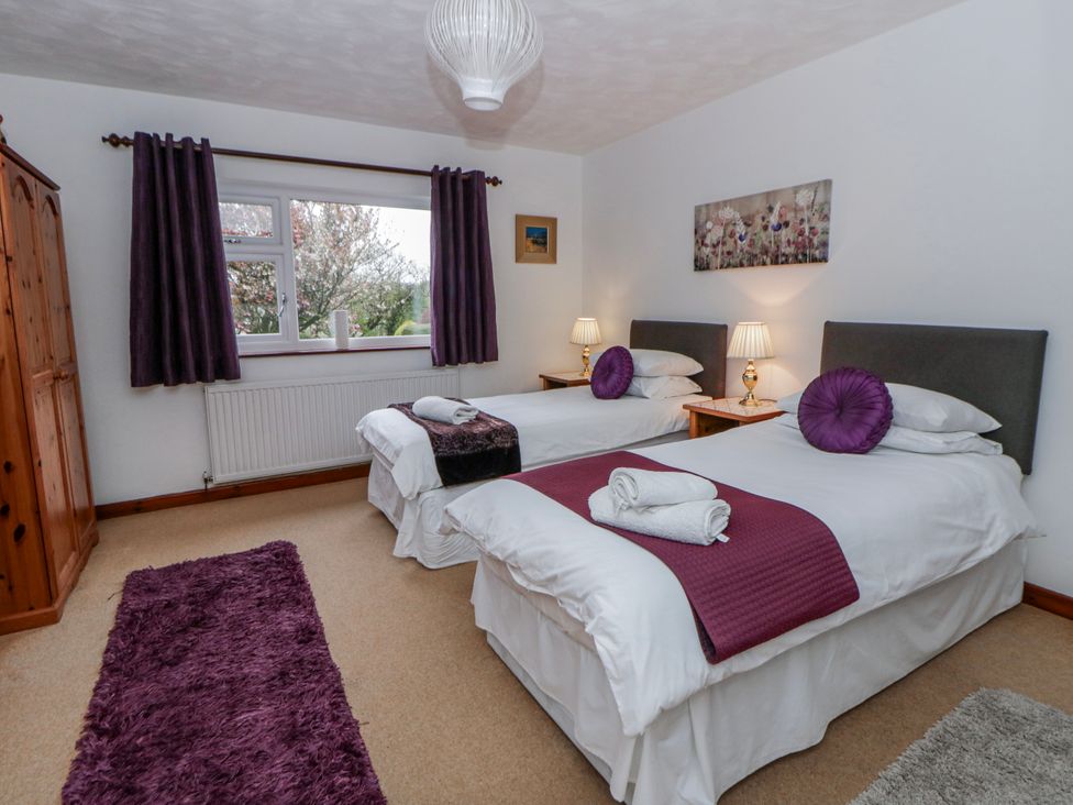 A bedroom with two single beds and a wardrobe at Blaenywawr near Lampeter