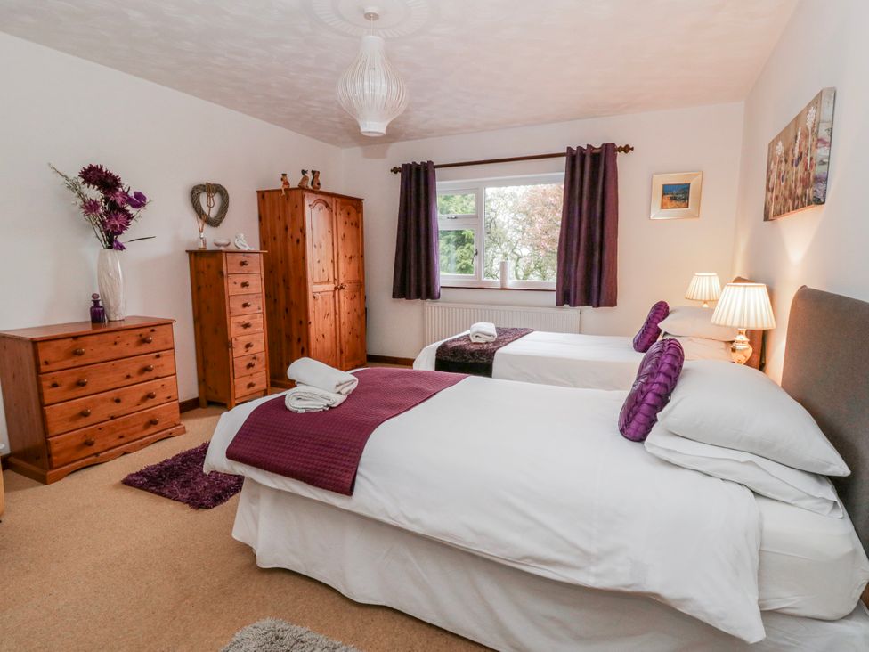 A bedroom with two beds and wooden furniture at Blaenywawr near Lampeter