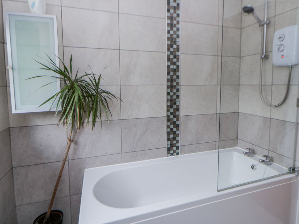 A bathroom with a bathtub and showerhead at Blaenywawr near Lampeter