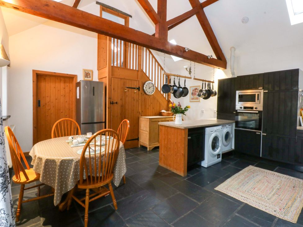 A kitchen with a table and chairs at Beudy Mawr Y Felinheli
