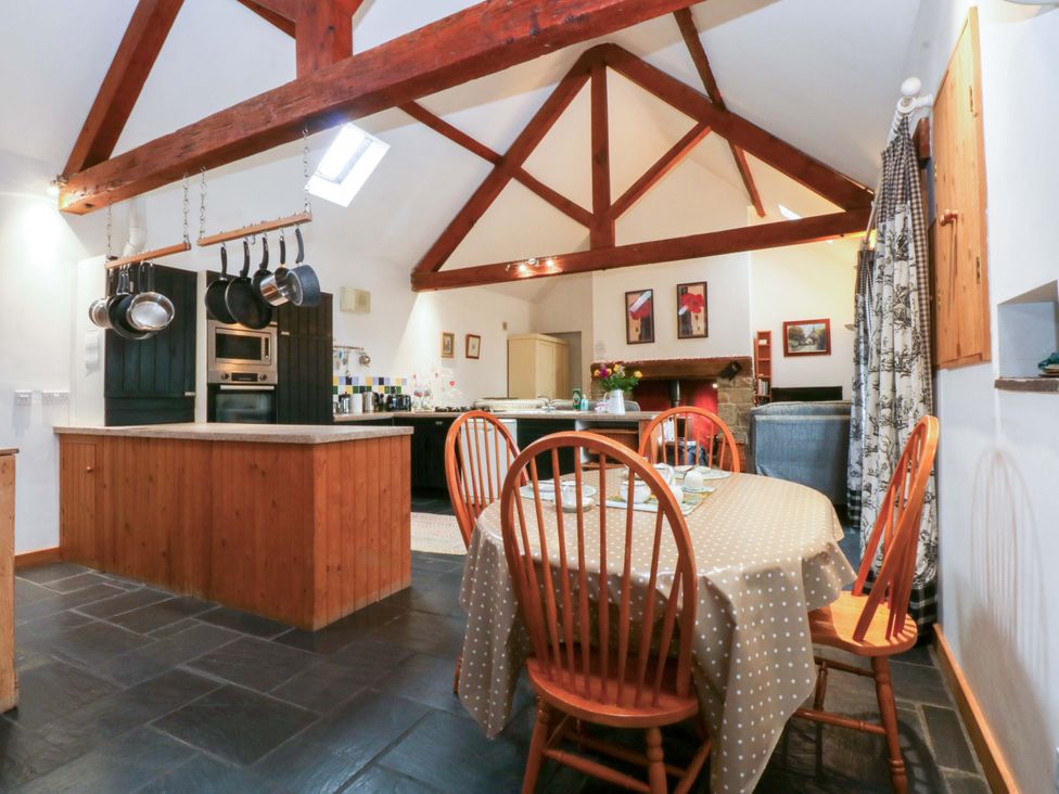 A kitchen with a dining table and chairs at Beudy Mawr Y Felinheli