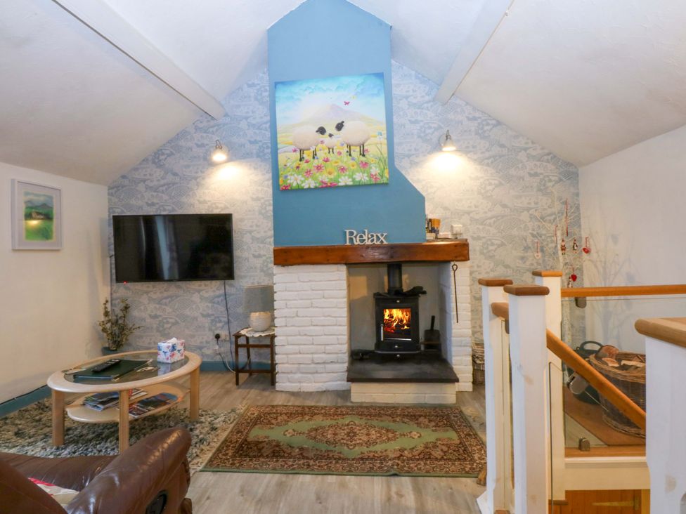A living room with a fireplace and television at Hafod in Y Felinheli