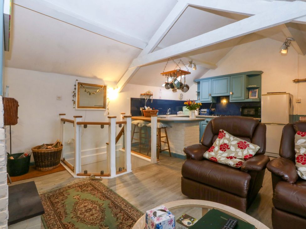 A living room with a kitchen area and seating at Hafod in Y Felinheli