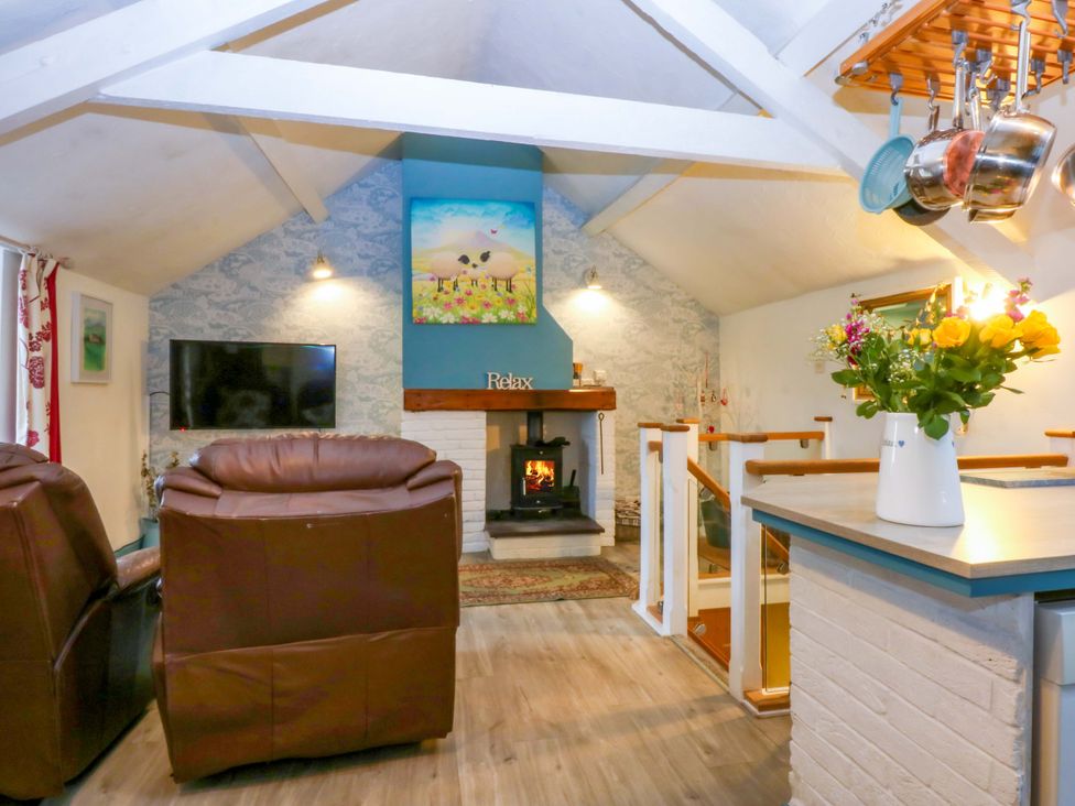 A living room with a fireplace and television at Hafod in Y Felinheli