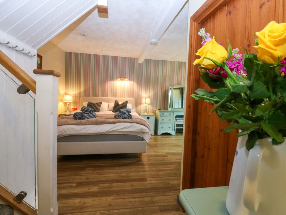 A bedroom with a bed and nightstands at Hafod Y Felinheli