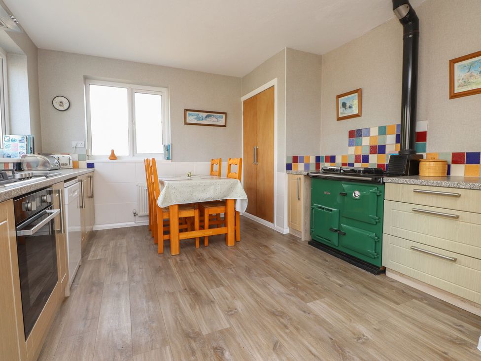 A kitchen with a dining table and chairs at The Farmhouse in Brynsiencyn near Newborough