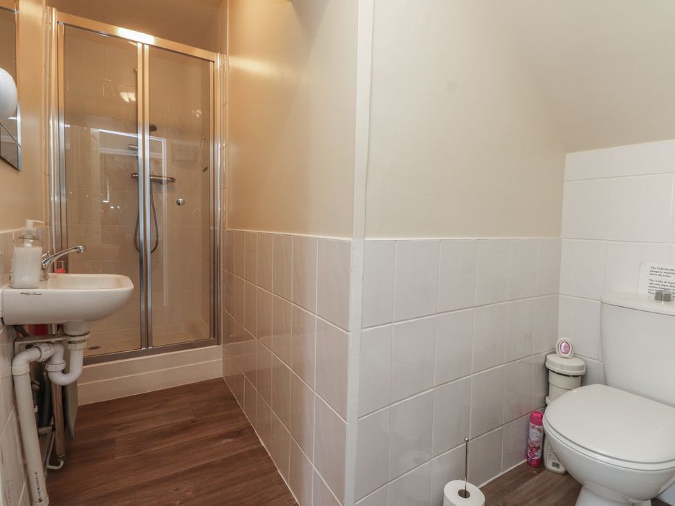 A bathroom with a shower, sink, and toilet at The Farmhouse in Brynsiencyn near Newborough