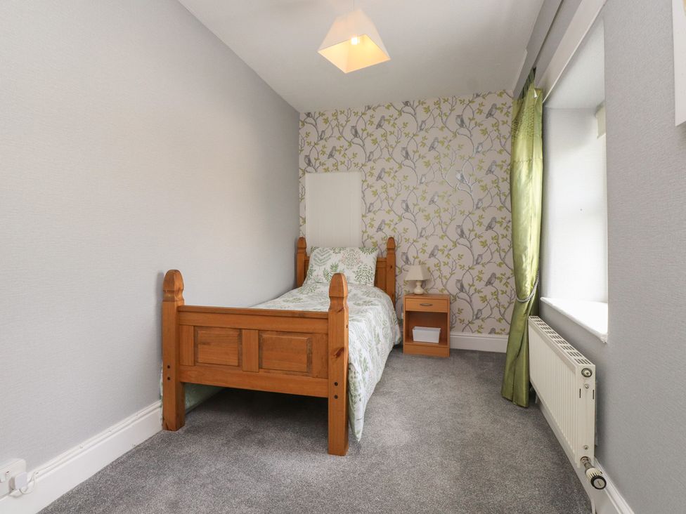 A bedroom with a bed and nightstand at The Farmhouse in Brynsiencyn near Newborough