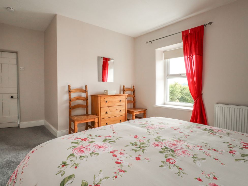 A bedroom with a bed and dresser at The Farmhouse in Brynsiencyn near Newborough