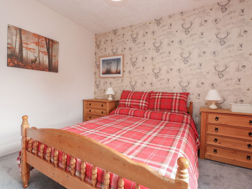 A bedroom with a bed and nightstands at The Farmhouse in Brynsiencyn near Newborough