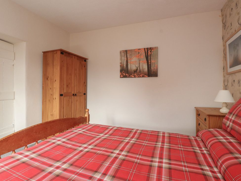 A bedroom with a bed and furniture at The Farmhouse in Brynsiencyn near Newborough