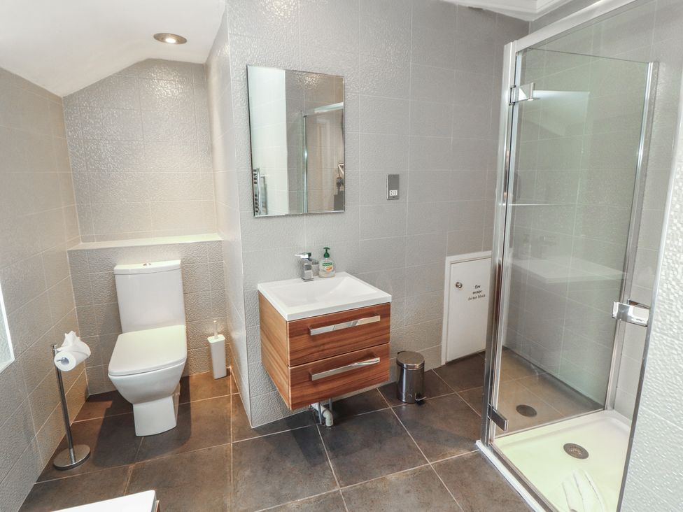 A bathroom with a toilet, sink, and shower at Kelsick Heights in Ambleside