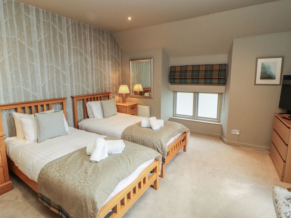 A bedroom with two beds and a dresser at Kelsick Heights in Ambleside