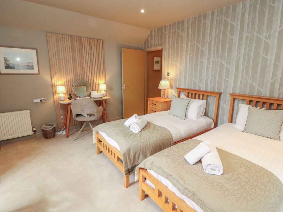 A bedroom with twin beds and a desk area at Kelsick Heights in Ambleside