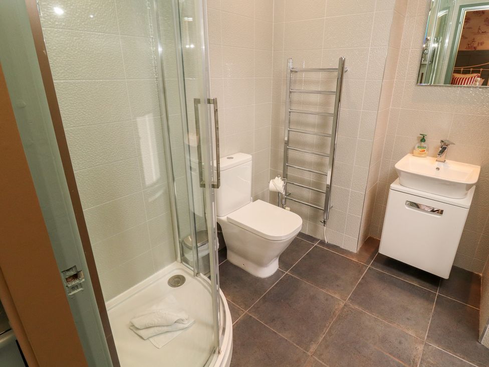 A bathroom featuring a shower, toilet, sink, and towel rail at Kelsick Heights, Ambleside