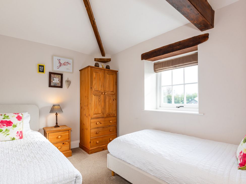 A bedroom with two beds and furniture at Carleton Mill Cottage Carlisle