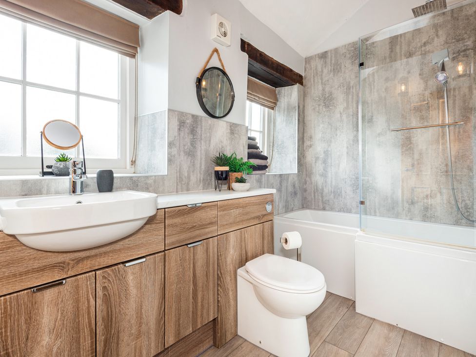 A bathroom with a sink, toilet, and bathtub at Carleton Mill Cottage in Carlisle