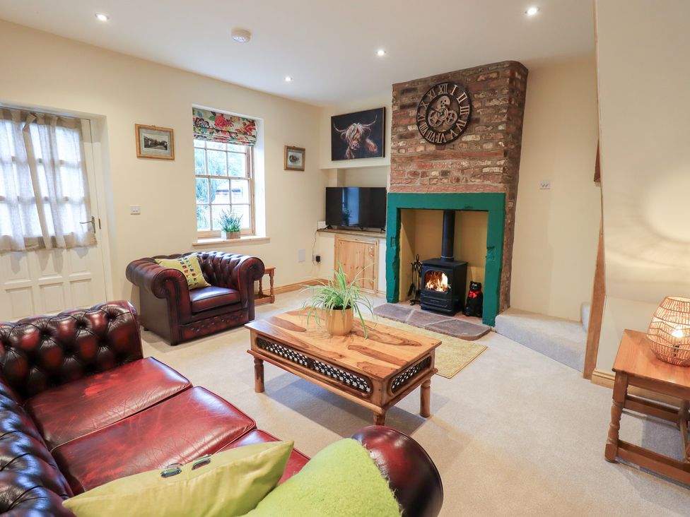 A living room with a fireplace and sofa at Rose Cottage in Crosby on Eden near Carlisle