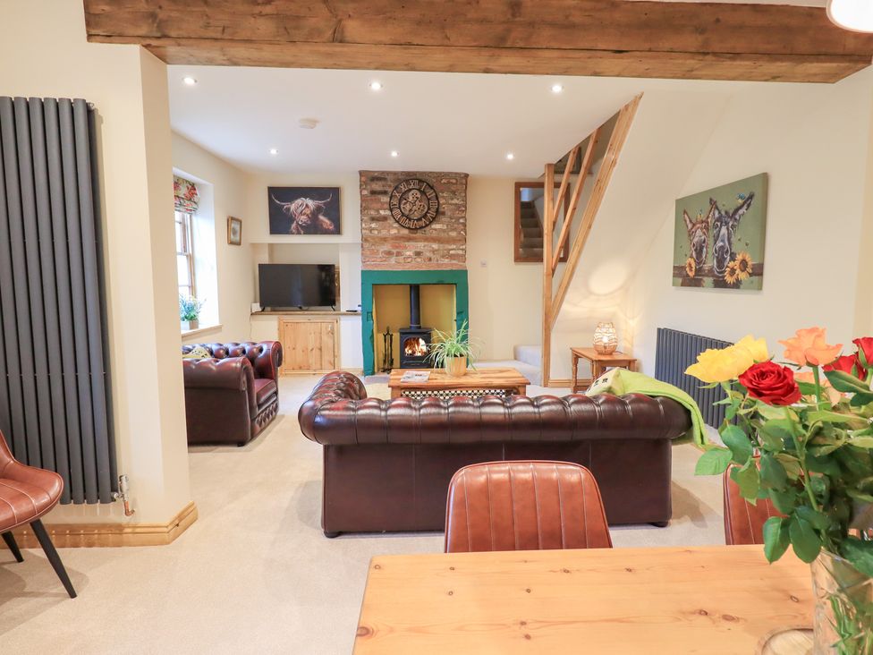 A living room with a sofa, coffee table, and fireplace at Rose Cottage in Crosby on Eden near Carlisle