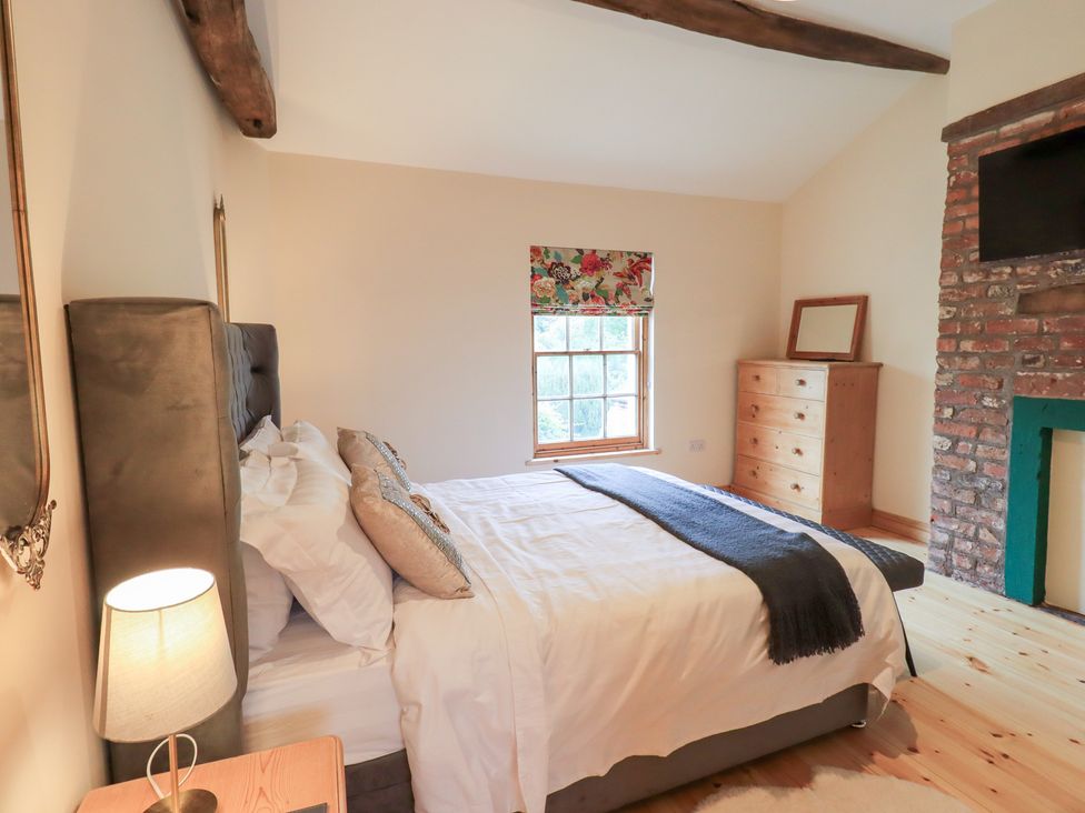 A bedroom with a bed and dresser at Rose Cottage in Crosby on Eden near Carlisle