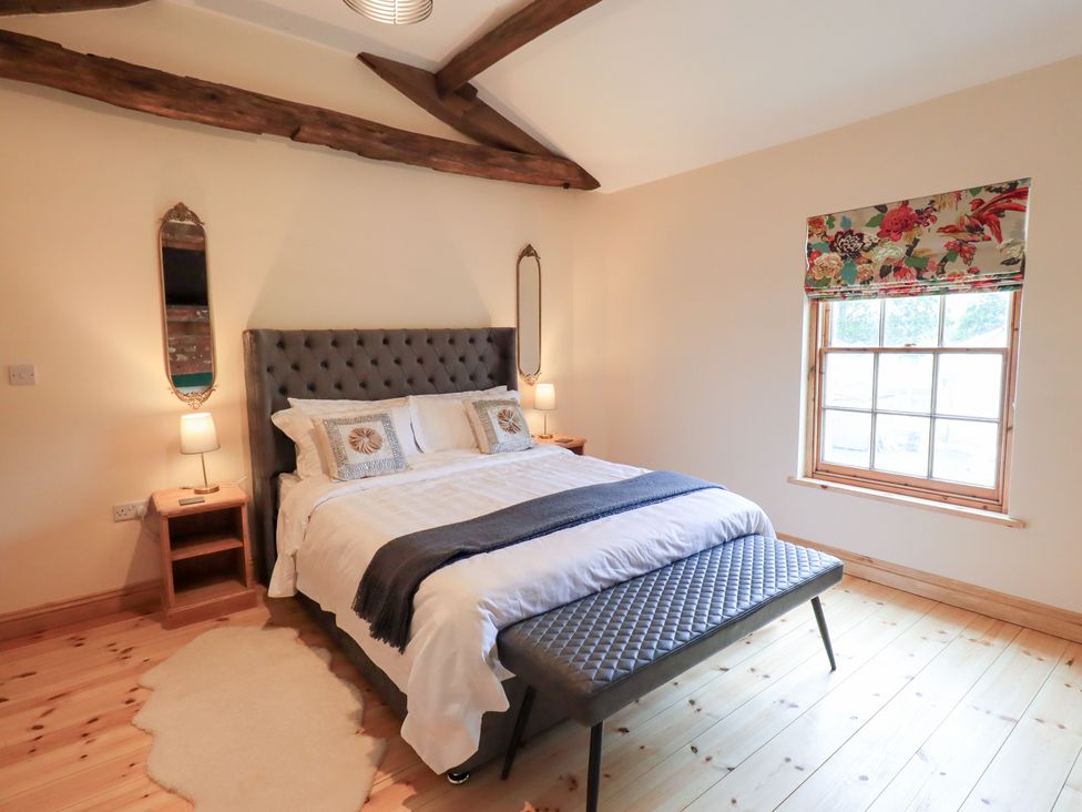 A bedroom featuring a bed, bedside tables and a window at Rose Cottage Crosby on Eden near Carlisle