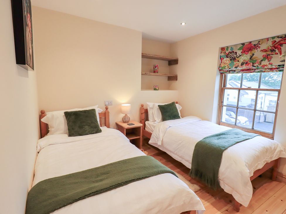 A bedroom with two beds and a lamp at Rose Cottage in Crosby on Eden near Carlisle