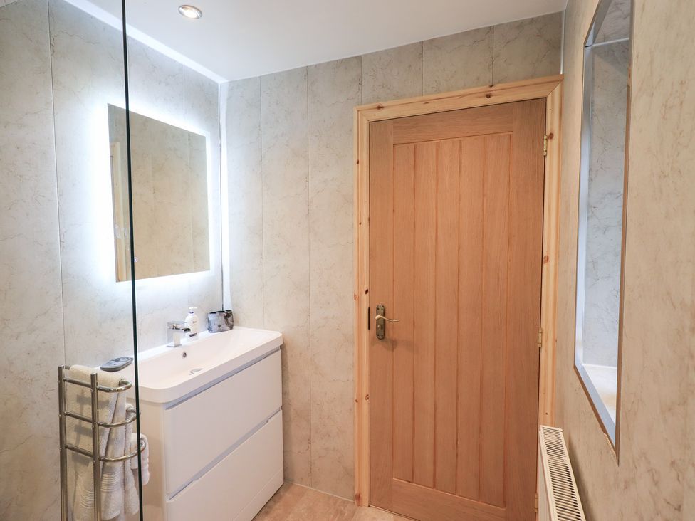 A bathroom with a sink, mirror and towel rack at Rose Cottage in Crosby on Eden near Carlisle
