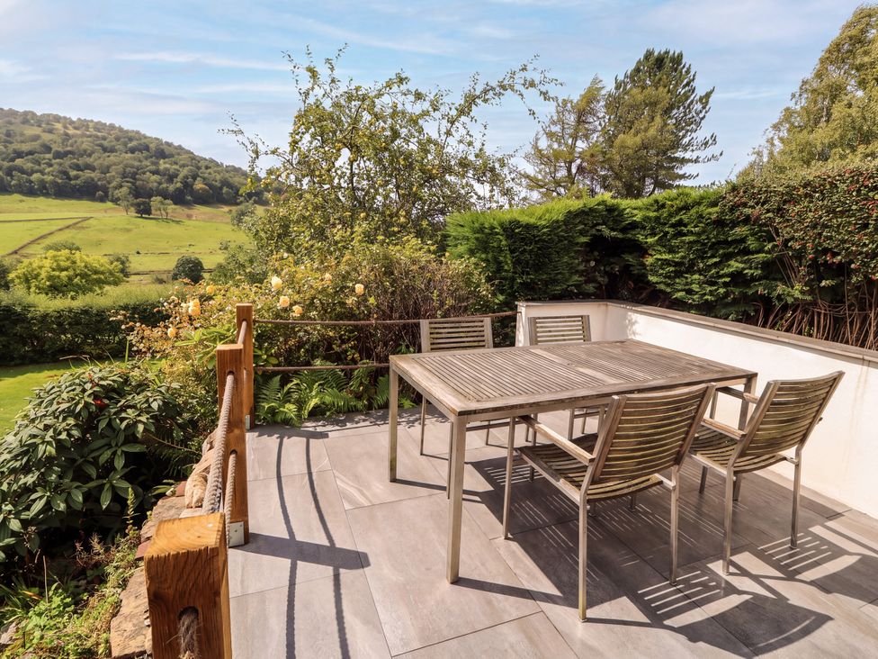 An outdoor seating area with a table and chairs at Mell View Cottage Ullswater