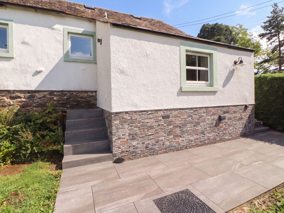 An exterior view of a house showing a stone wall and steps at Mell View Cottage Ullswater