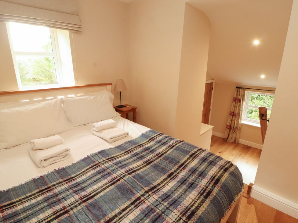 A bedroom with a bed and a nightstand at Mell View Cottage in Ullswater