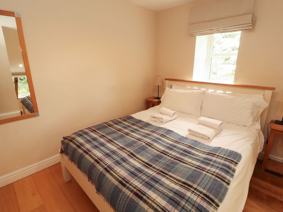 A bedroom with a bed and mirror at Mell View Cottage Ullswater