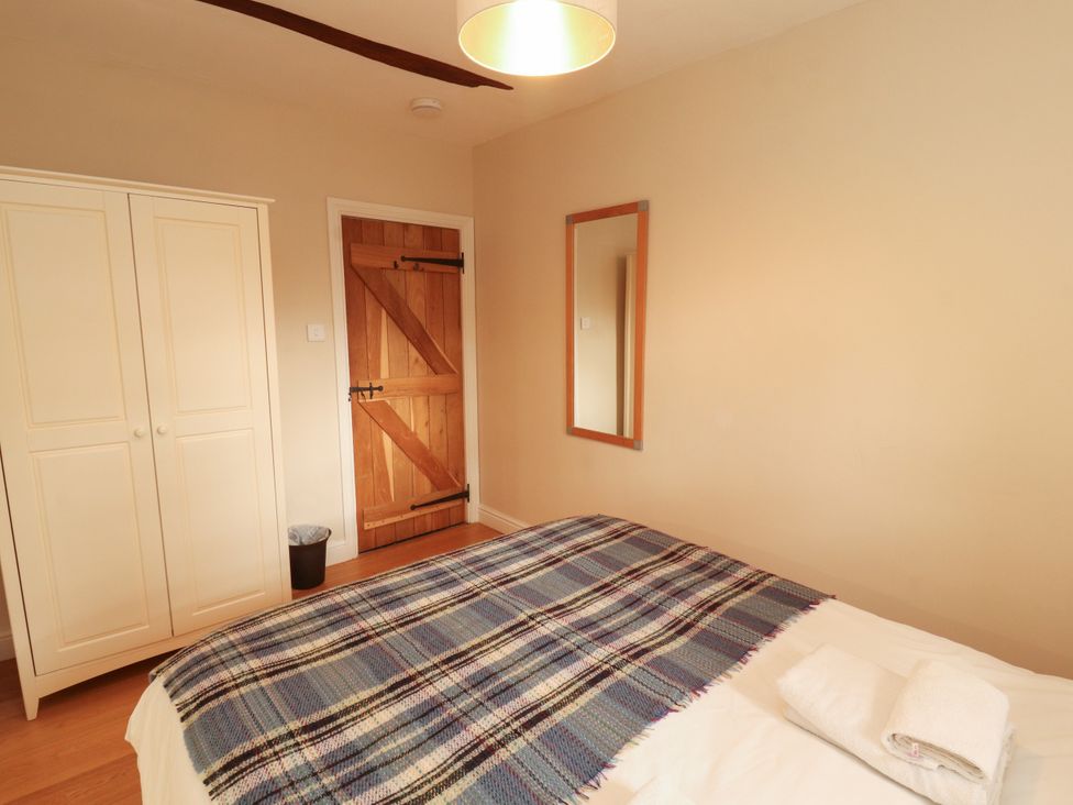 A bedroom with a bed and wardrobe at Mell View Cottage Ullswater