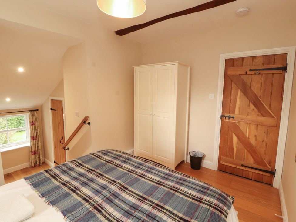 A bedroom with a bed and wardrobe at Mell View Cottage in Ullswater