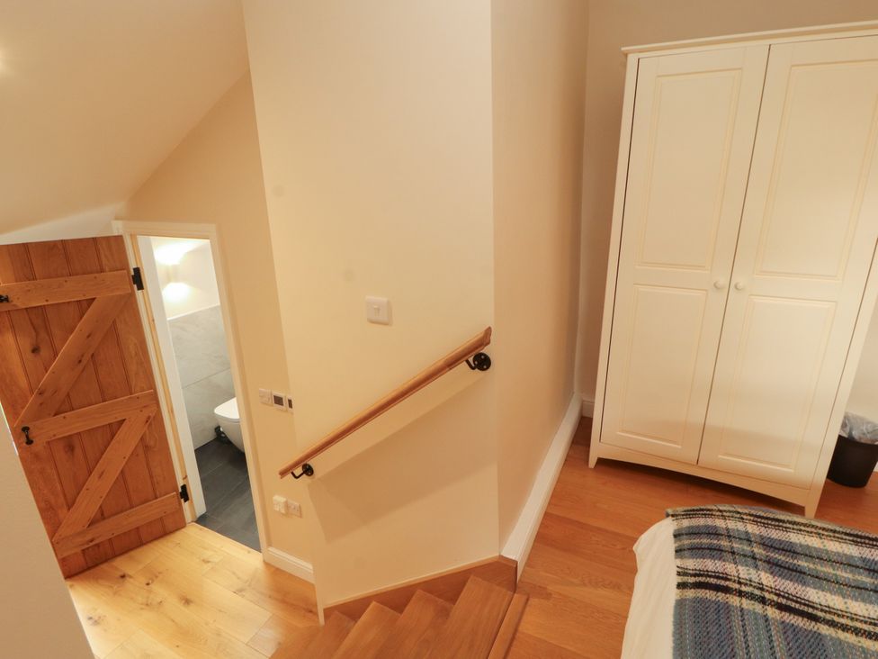 A hallway with a staircase and wardrobe at Mell View Cottage in Ullswater