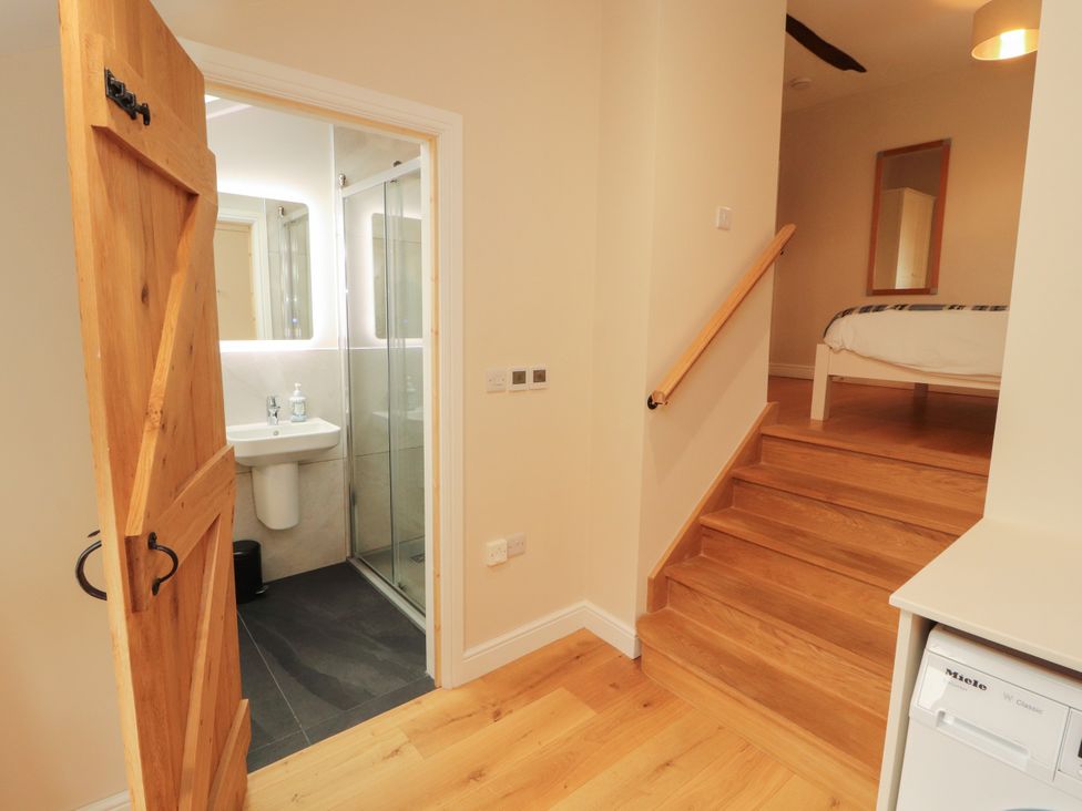A hallway with a staircase and shower room at Mell View Cottage in Ullswater
