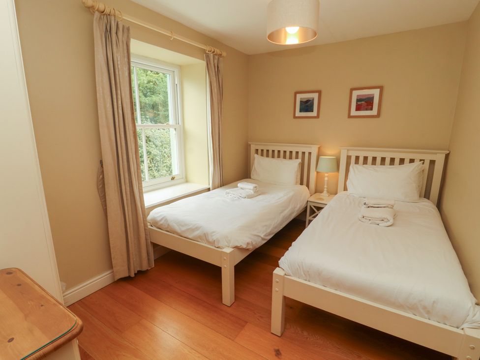 A bedroom with two beds and a lamp at Mell View Cottage in Ullswater