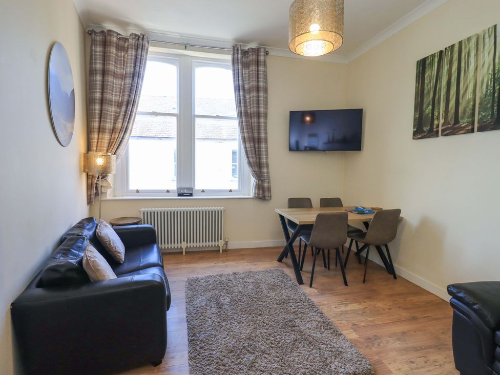 A living room with a sofa and dining area at St Johns View in Keswick