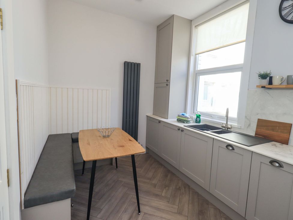 A kitchen with a table and bench at St Johns View in Keswick