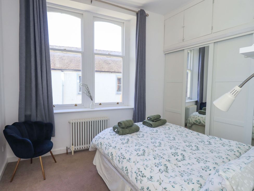 A bedroom with a bed and chair at St Johns View in Keswick