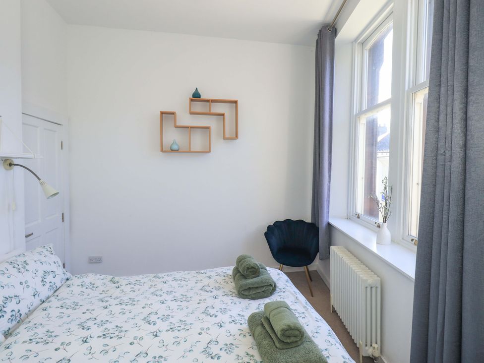 A bedroom with a bed and decorative shelves at St Johns View in Keswick