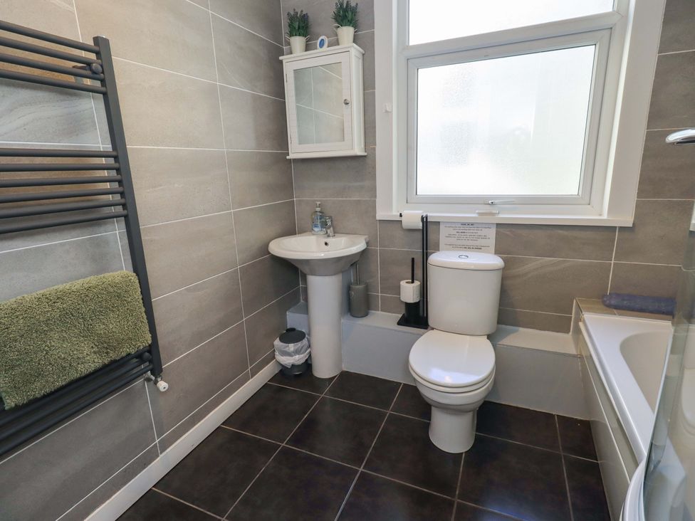 A bathroom with a sink, toilet, and towel rack at St Johns View in Keswick