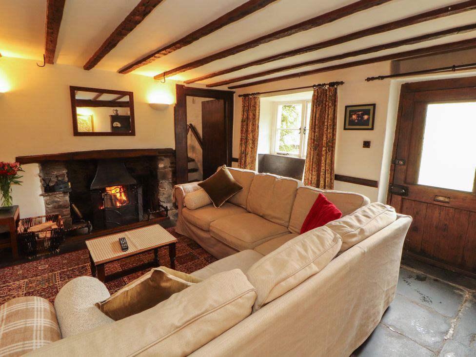 A living room with a sofa and fireplace at Mill Cottage in Garnett Bridge