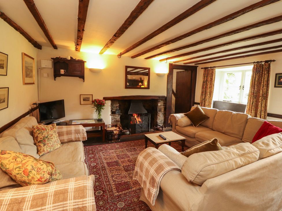 A living room with a television and fireplace at Mill Cottage in Garnett Bridge