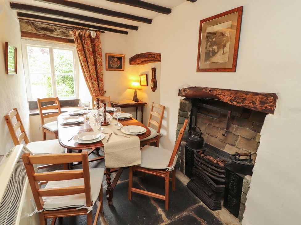 A dining room with a table and chairs at Mill Cottage in Garnett Bridge